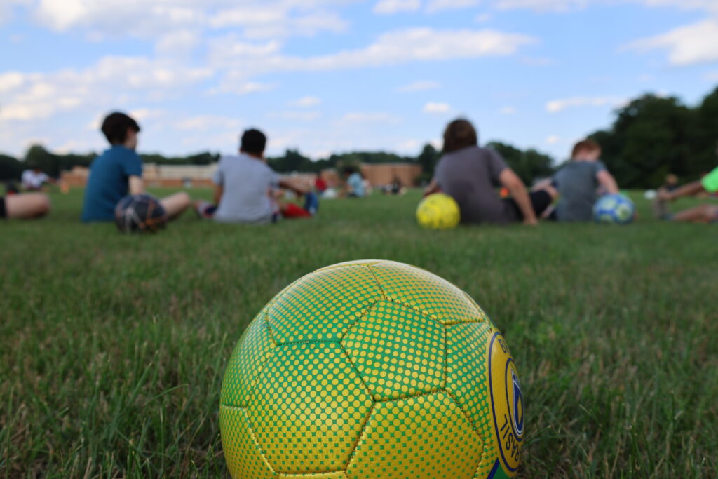 soccer ball with campers sitting in the background