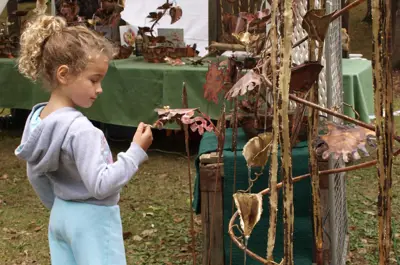 child looking at large metal sculpture